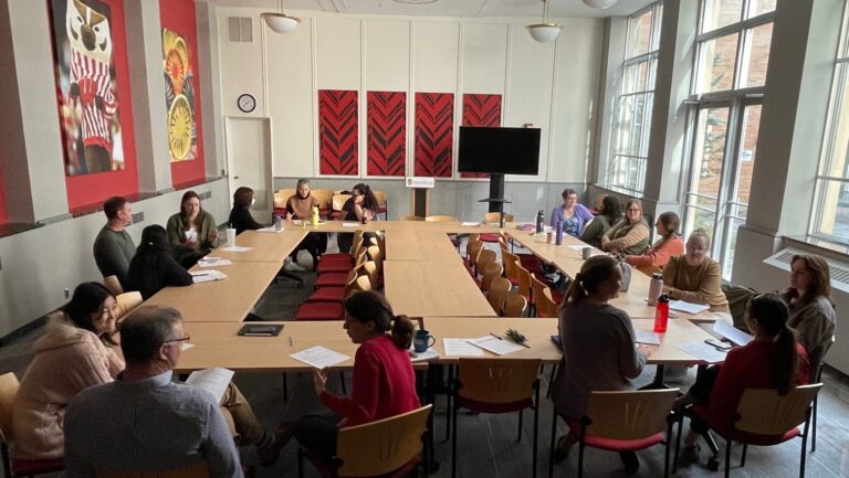 College of Engineering Faculty and Staff sit around a table, talking.
