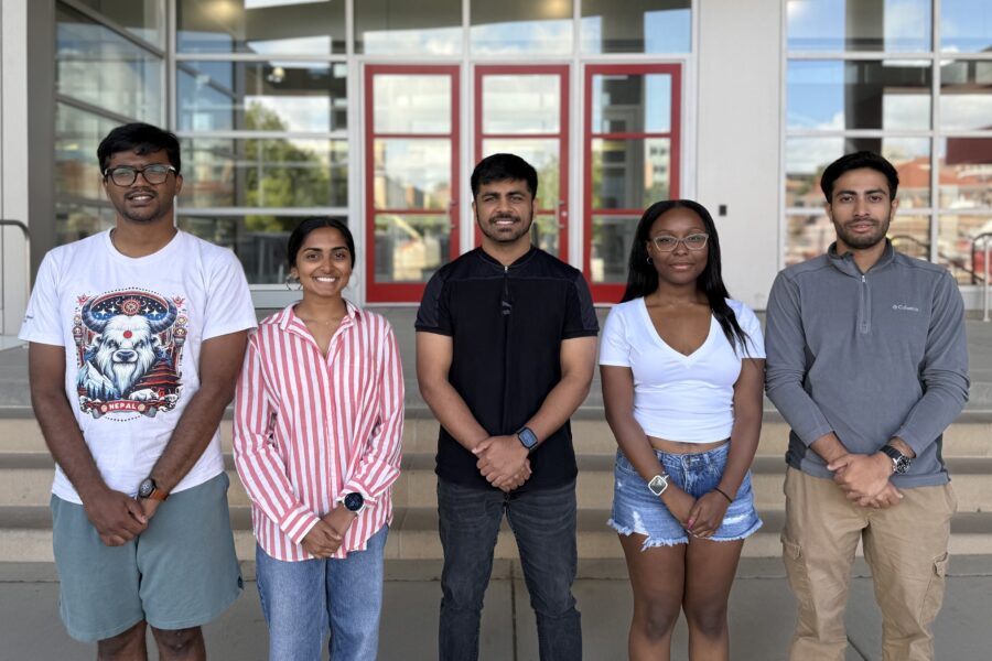Five ECE graduate students standing in a row in front of Engineering Hall
